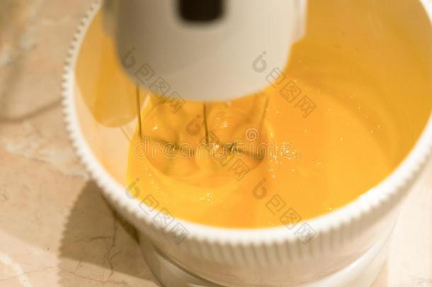 一厨房搅拌器打黄色的鸡蛋蛋黄为新鲜的蛋糕生面团采用