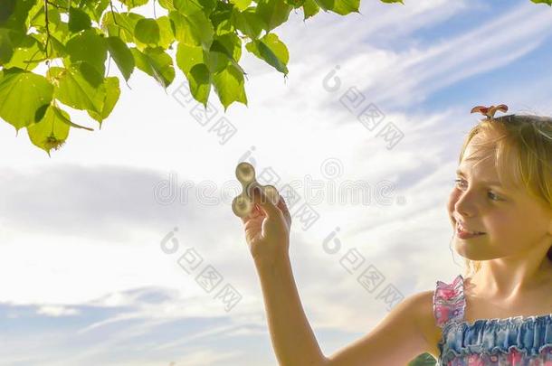 一年幼的明亮的女孩给看一纺纱机.