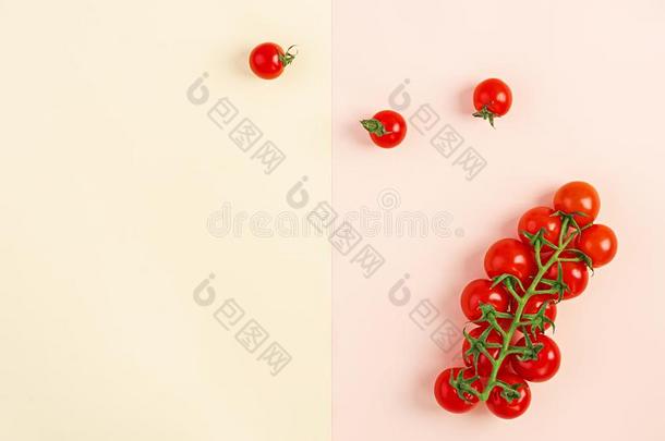 隔离的新鲜的红色的樱桃番茄向黄色的-米黄色背景.英语字母表的第20个字母