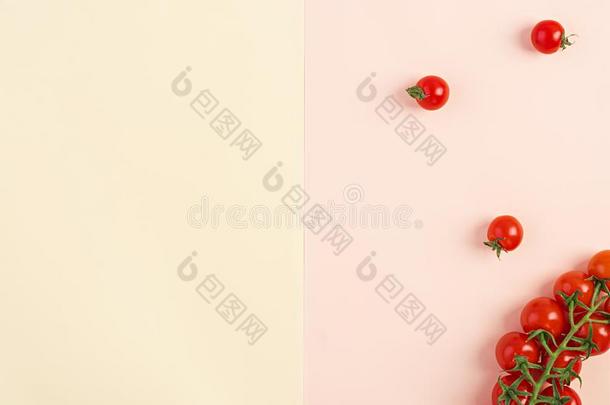 隔离的新鲜的红色的樱桃番茄向黄色的-米黄色背景.英语字母表的第20个字母