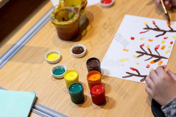 小的女孩绘画和使用多彩的绘画器具