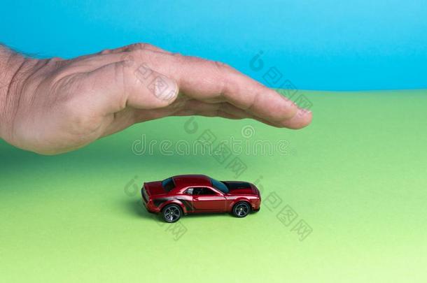 红色的汽车玩具大量的在旁边手.<strong>汽车保险</strong>观念