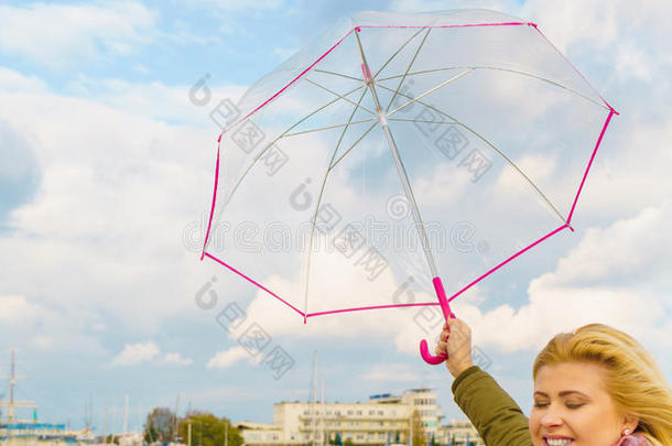 女人起立和<strong>透明</strong>的<strong>雨伞</strong>向海滩