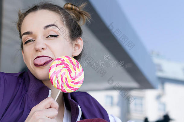 现代的十几岁的青少年女孩和糖果给看舌头