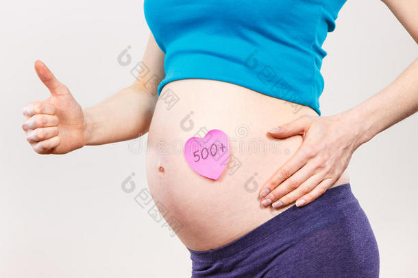 怀孕的女人和题词500+展映拇指在上面,社会的英语字母表的第16个字母