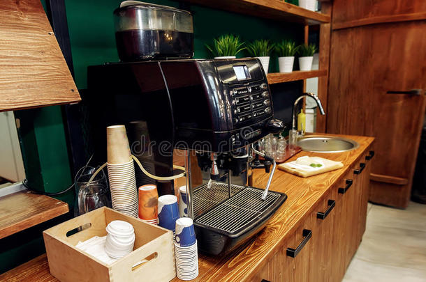 时髦的咖啡豆机器和纸杯子向木制的书桌.拿向走