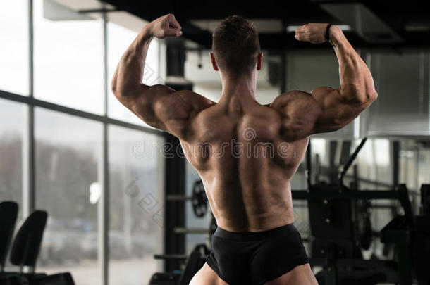 肌肉的男人挠曲背肌肉使摆姿势