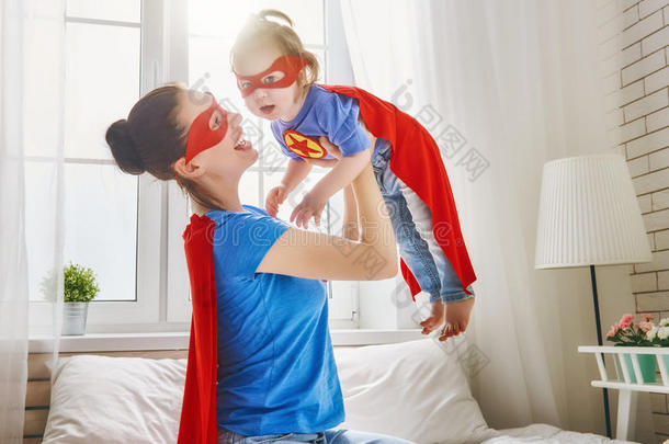 女孩和妈妈采用超级英雄戏装