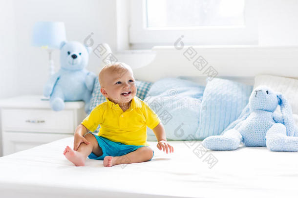 婴儿男孩演奏向床采用和煦的：照到阳光的婴儿室