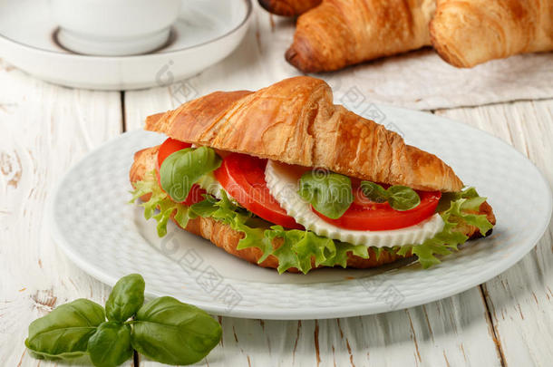 早餐.三明治羊角面包和奶酪,番茄和罗勒属植物.英语字母表的第3个字母