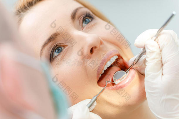 美丽的中部老年的女人在牙齿的检查在上面