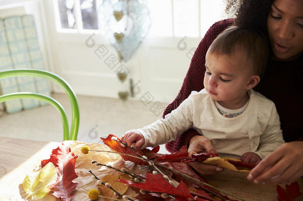 母亲和女儿制造秋装饰在家