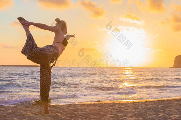 女人开业的<strong>瑜伽</strong>向海海滩在<strong>日</strong>落.