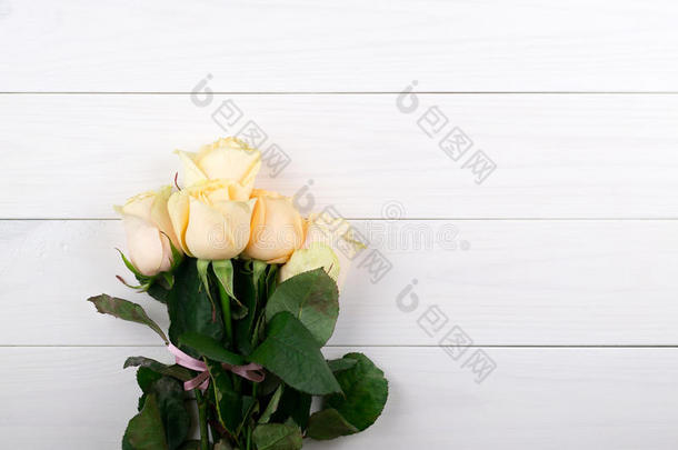 <strong>花</strong>束关于米黄色玫瑰向白色的木制的酿酒的背景,平的