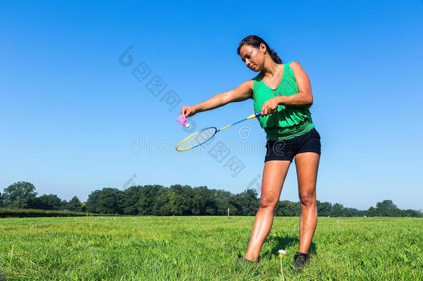 女人服务和<strong>羽毛球</strong>球拍和梭子在外面采用草