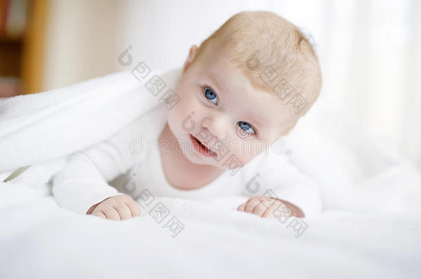 婴儿女孩使人疲乏的白色的毛巾或冬奥瓦尔采用白色的和煦的：照到阳光的是
