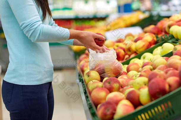 女人和袋购买苹果在食品杂货店商店