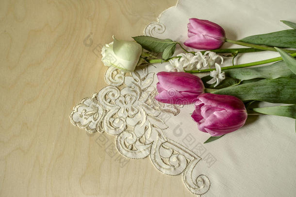 白色的玫瑰和风信子和紫色的郁金香向绣花的表c