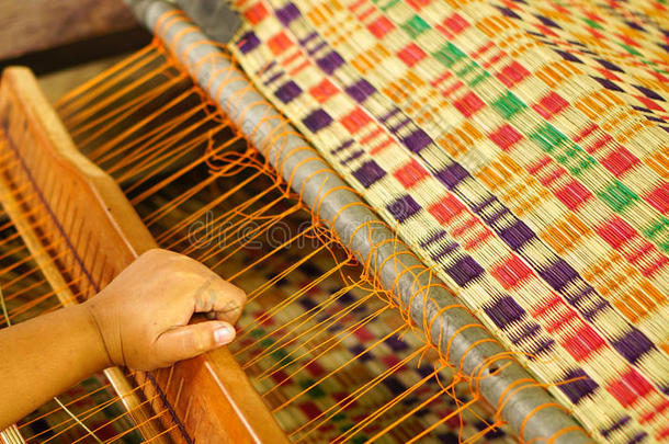 亚洲人女人是制造纺织品为家庭使用.