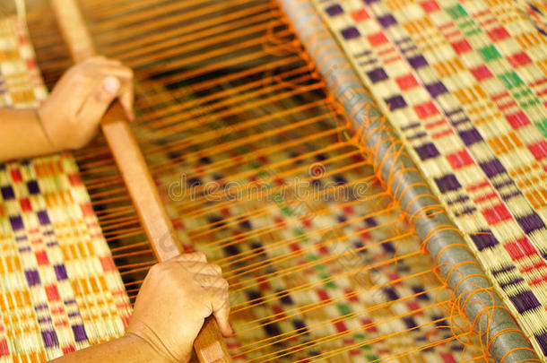 亚洲人女人是制造纺织品为家庭使用.