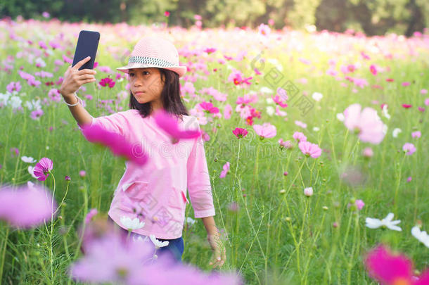 女孩自拍照照相机自拍照聪明的电话采用花花园