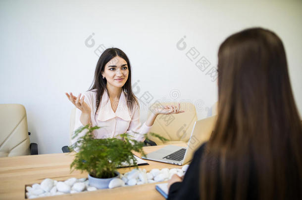 两个成功的女<strong>商</strong>人一次在书桌和讲话在使工作