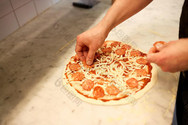烹调手加意大利腊肠向意大利薄饼在匹萨饼店
