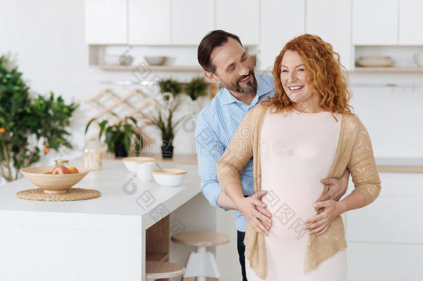丈夫拥抱他的满的学期怀孕的妻子