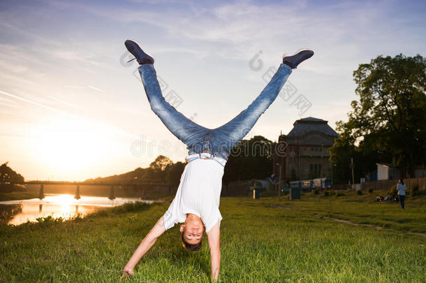十几岁的青少年男孩用于跳跃的采用指已提到的人公园在日落