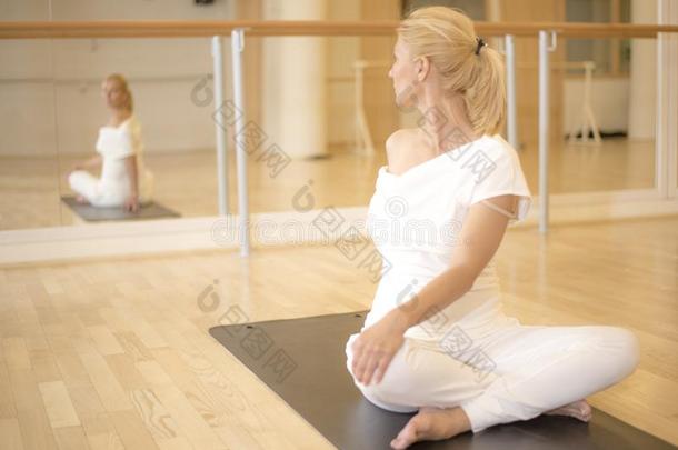 女人开业的瑜伽采用莲花twist采用g使摆姿势