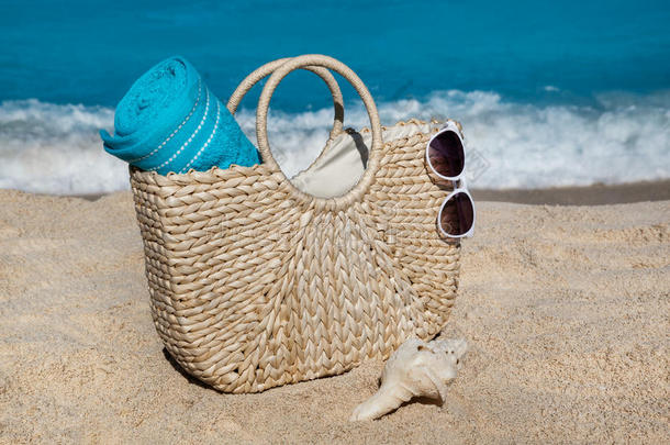 稻草袋和蓝色毛巾和太阳镜向热带的s和海滩