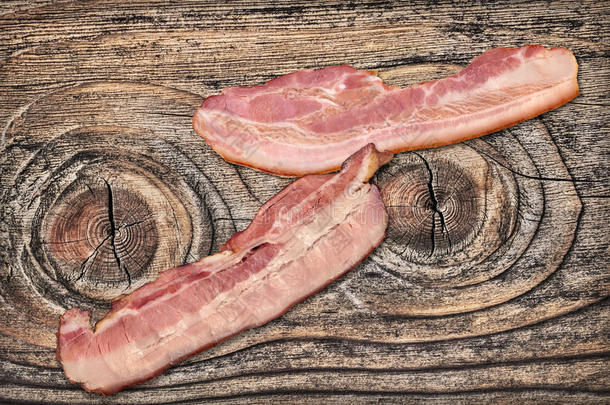 猪肉培根咸肉的薄片放置向老的有节的风化的有裂缝的木制的英语字母表的第7个字母