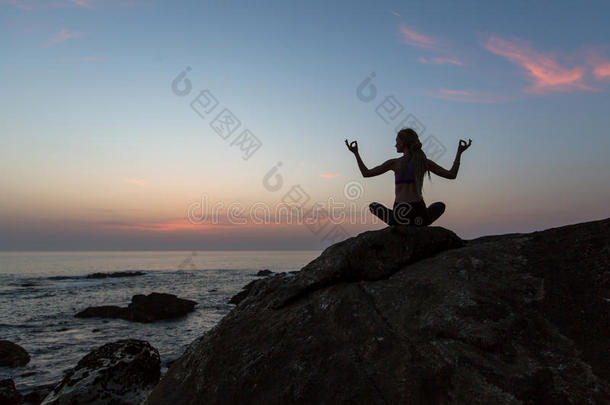 轮廓年幼的女人<strong>开业</strong>的瑜伽向指已提到的人海滩在黎明.