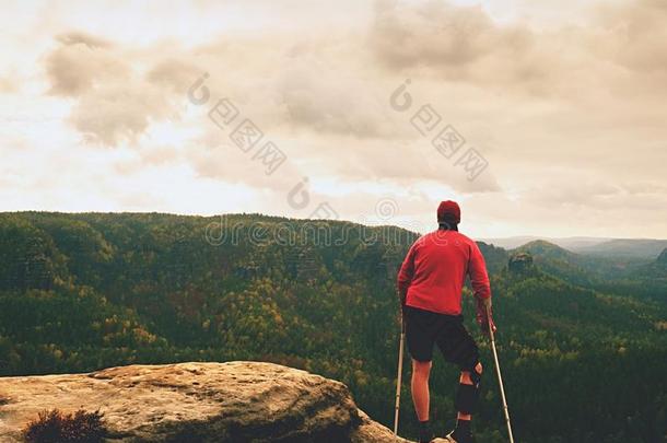 男人和前臂拐杖.远足者取得山山峰和打破