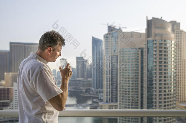 中部老年的男人在他的阳台忽视指已提到的人小艇船坞