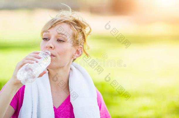 适合年幼的女人在户外和毛巾喝饮料从她怀特