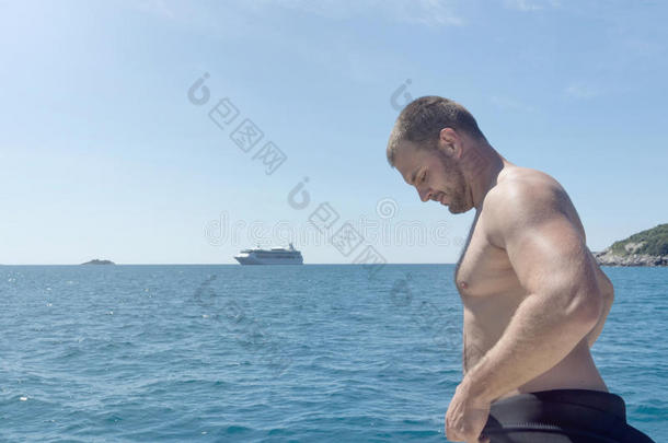 水肺潜水员向小船,放置向他的潜水服.