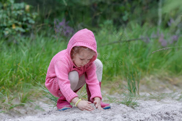 小的女孩演奏和沙采用夏森林