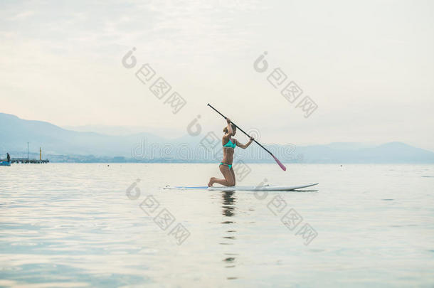 年幼的美丽的斯拉维安女人旅行者<strong>开业</strong>的宽叶短桨木板