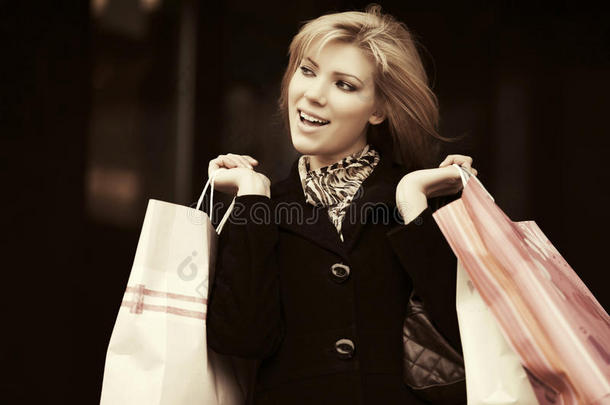 幸福的年幼的时尚女人和购物袋采用指已提到的人购物中心