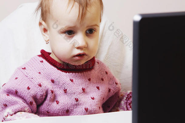 小的婴儿女孩工厂和指已提到的人便携式电脑<strong>幽默</strong>的照片