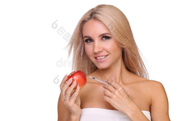 美丽的女人和注射器关于红色的疫苗剂量注射向苹果
