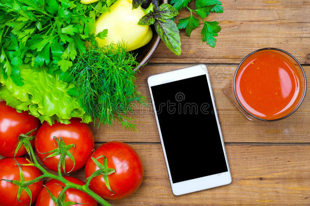新鲜的番茄果汁,番茄es和智能手机向一木制的t一ble向