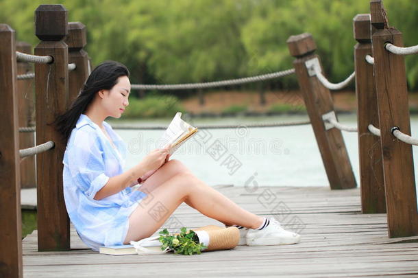 中国人女孩阅读书.白肤金发碧眼女人美丽的年幼的女人和嘘声