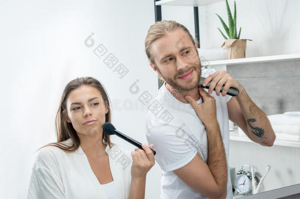 男人剃胡子胡须和<strong>整顿</strong>者在期间妻子应用面容粉