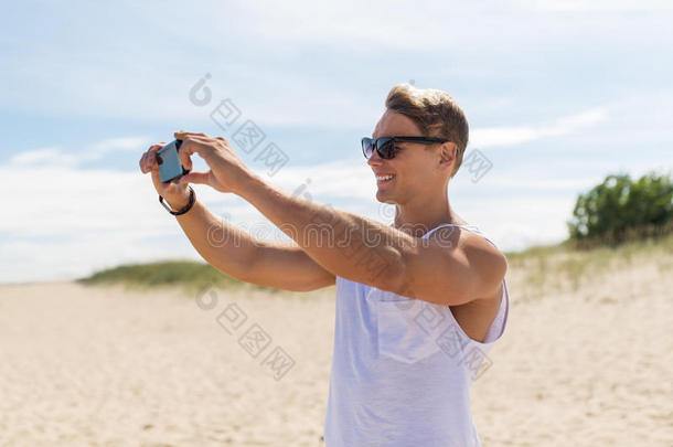 男人和智能<strong>手机摄影</strong>向夏海滩