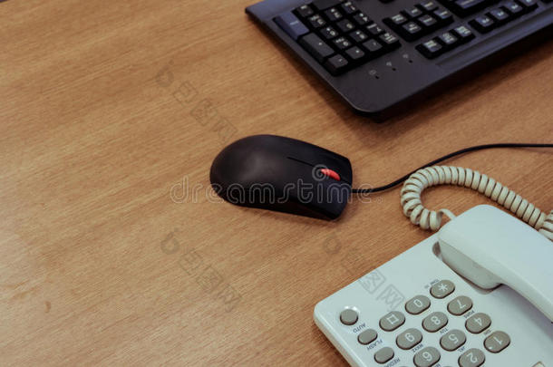 办公室书桌木材表和键盘personalcomputer个人计算机,老鼠和书桌电话.