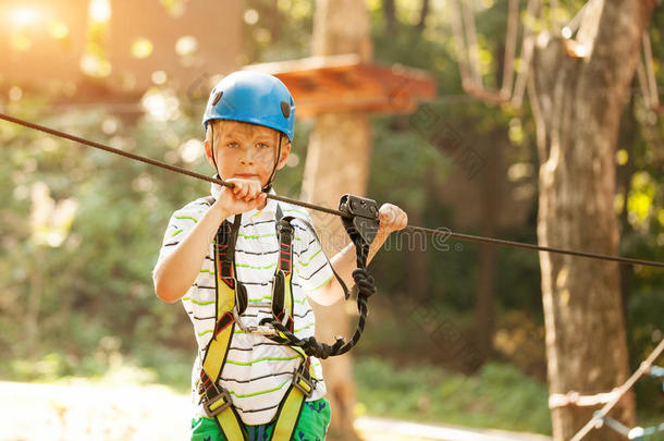 幸福的男孩在冒险活动和攀登的索道活动采用森林