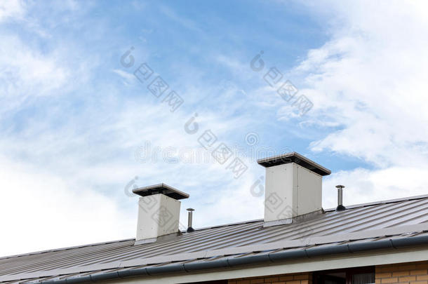 湿的金属屋顶和烟囱反对蓝色多云的天