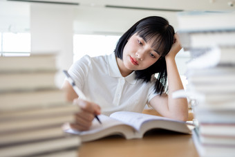 图书馆看书的女大学生学习阅读读书写作业